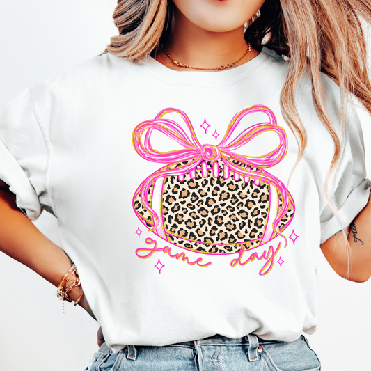 White t-shirt with a pink bow and leopard print design on a white background