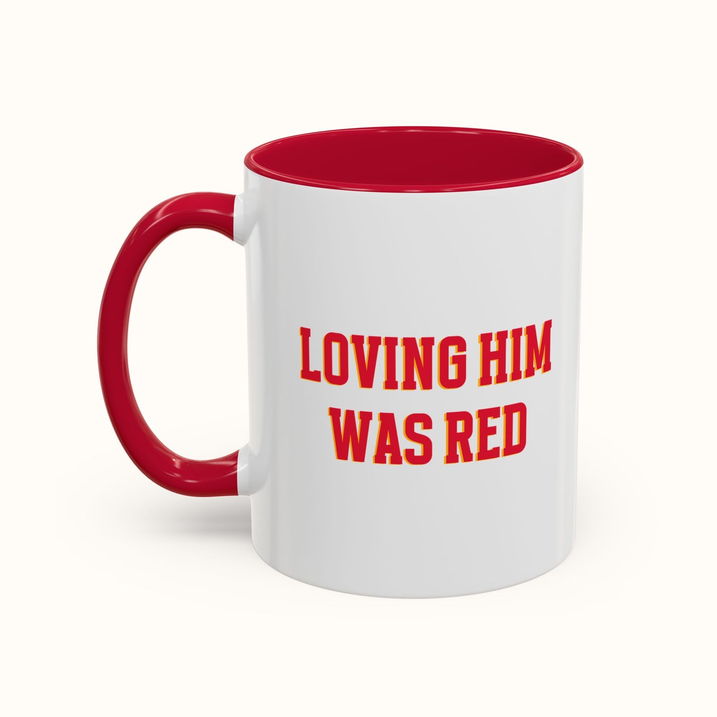White mug with red interior and handle, featuring the text 'LOVING HIM WAS RED' on a white background.