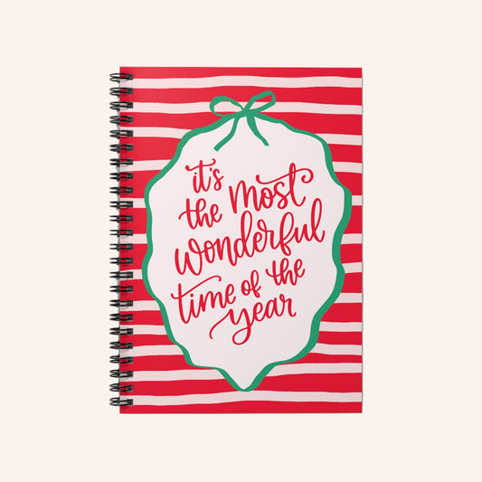 Notebook with red and white striped cover and 'it's the most wonderful time of the year' text.