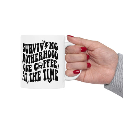 SURVIVING MOTHERHOOD ONE COFFEE AT A TIME - CERAMIC MUG