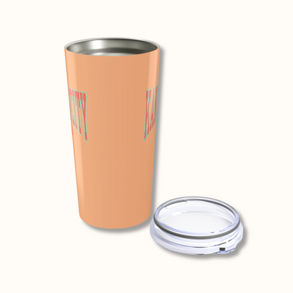 Peach-colored tumbler with a clear lid on a white background