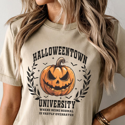 Beige t-shirt with Halloween-themed design featuring a pumpkin and text.