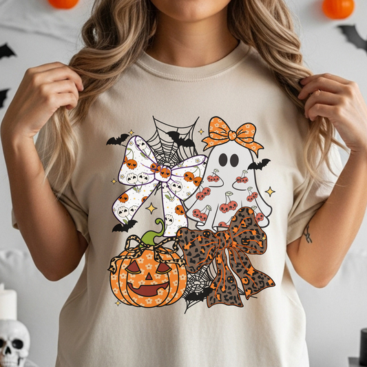 Person wearing a Halloween-themed t-shirt with graphics of ghosts, pumpkins, and bows.