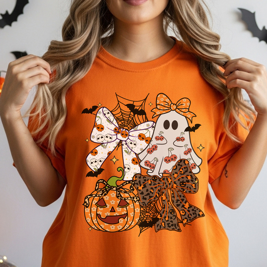 Person wearing an orange Halloween-themed t-shirt with ghosts, pumpkins, and bows.