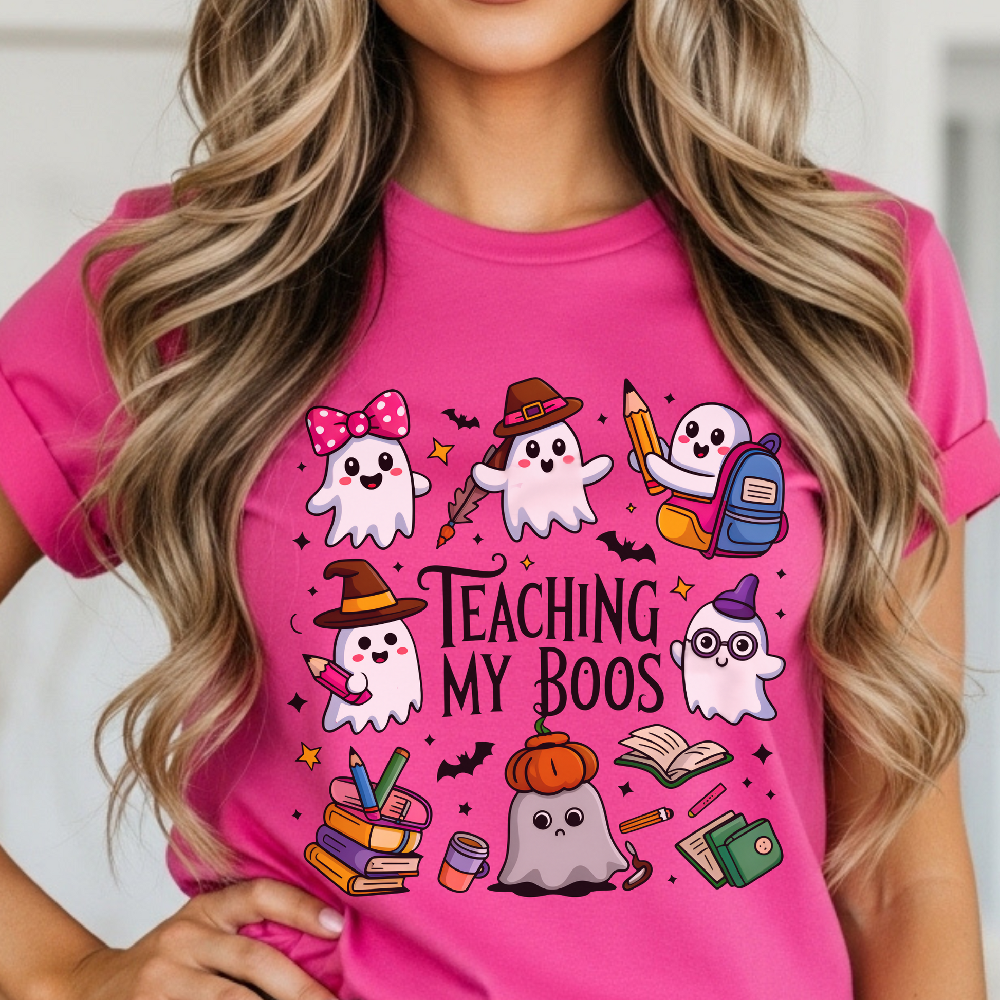 Person wearing a pink t-shirt with Halloween-themed TEACHER graphics and text.