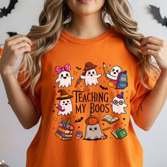 Person wearing an orange t-shirt with Halloween-themed TEACHER graphics and text.
