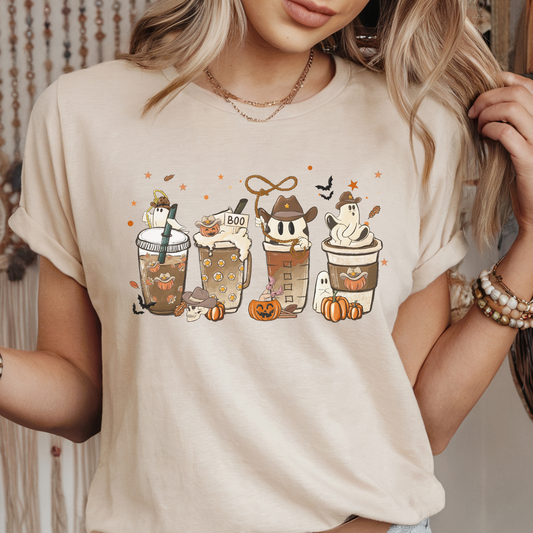 Person wearing a beige t-shirt with Halloween-themed coffee cup graphics.
