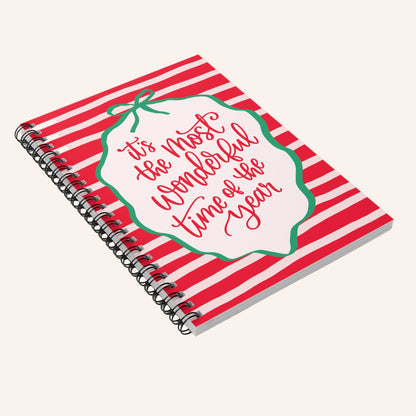 Notebook with red and white striped cover and Christmas-themed text on a white background