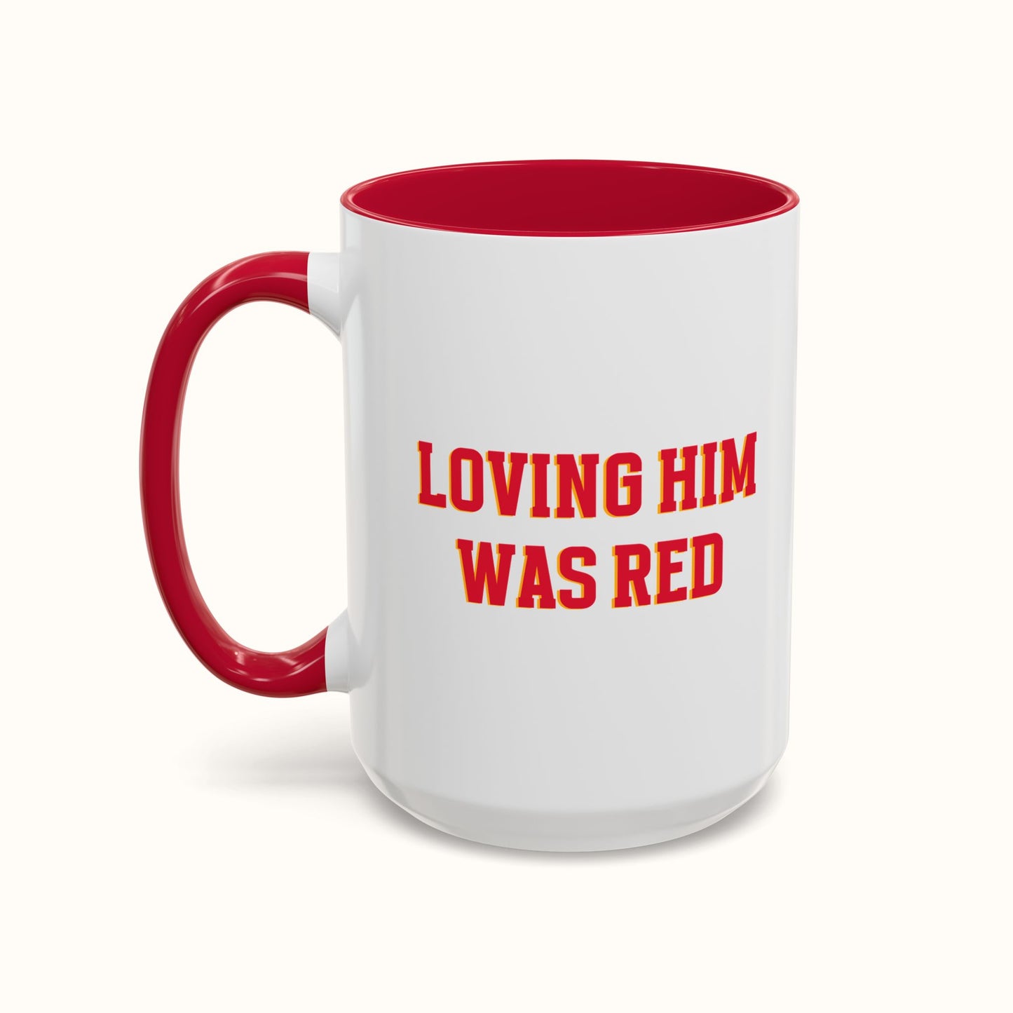 White mug with red interior and handle, featuring the text 'LOVING HIM WAS RED' on a white background.